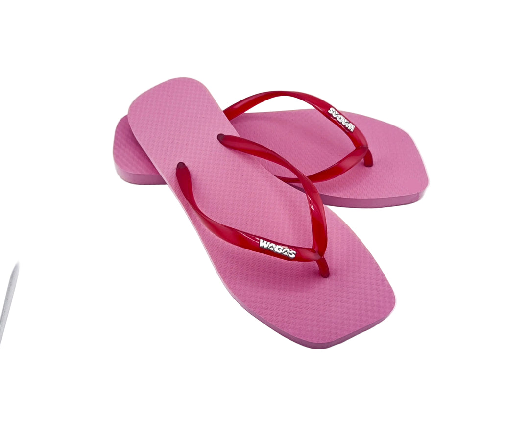 Pink flip-flops with red straps on a white background